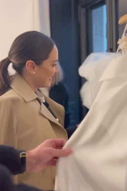 La novia en el atelier de las diseñadoras, mirando vestidos.
