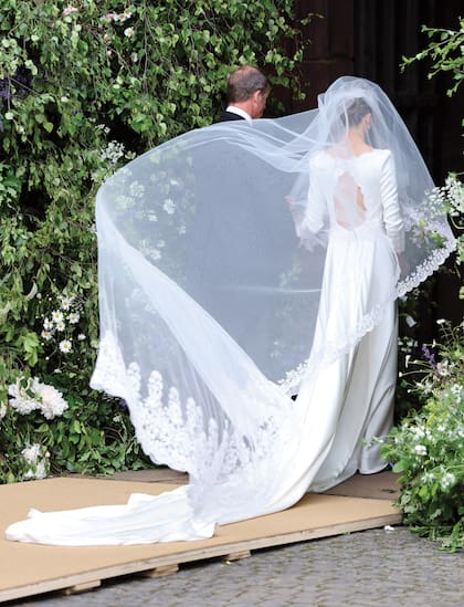 La novia ingresa del brazo de su padre, Ruper Henson. Una imagen, ayudada por el viento que hace volar el velo, que parece salida de una pelicula romántica.