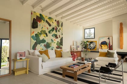 La obra de Rodrigo Rodríguez domina la escena en el living. Mesas ratonas y mesa de arrime (Bull Buenos Aires), sillas de cuero y aluminio (Zeta Home).