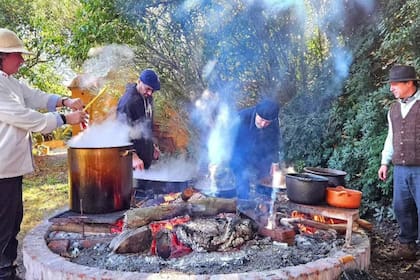 La olla de guiso se calienta lentamente al fuego de las brasas