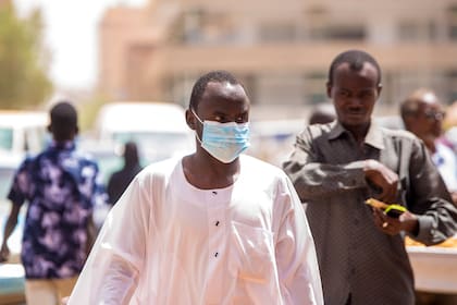 Sudaneses con barbijos en Khartum