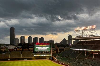 La pantalla gigante del Wrigley Field muestra una advertencia de tormenta, que obligó a posponer el juego del martes 24 de agosto de 2021, entre los locales Cachorros de Chicago y los Rockies de Colorado (AP Foto/Charles Rex Arbogast)