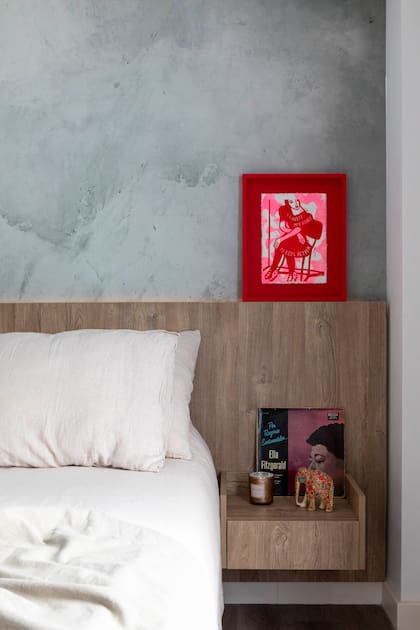 La pared principal está revestida con un empapelado (Bue Deco Wall Design) que simula un estucado verde oliva. Sobre el respaldo con mesas de luz flotantes, obra de la artista holandesa Erna Kuik (Details Enmarcado Artístico).