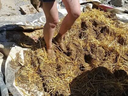 La pareja en plena acción: con los pies hicieron la mazorca, mezclando tierra, arcilla, paja y agua.