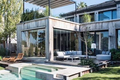La parrilla está en el volumen de la izquierda, con un cerramiento de vidrio plegable (Cristal Box).