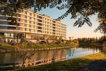 La particular forma del edificio, con curvas y contracurvas, organiza espacios exteriores equivalentes, hacia la entrada sobre el Este, y sobre el lago en el Oeste, alojando una pileta de proporciones únicas, muelle, jardines de vegetación tupida, y un recorrido completo en todo el contorno del terreno para caminar al borde del lago central.