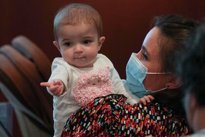La pequeña Emma, de 13 meses, en brazos de su madre Ana (The Associated Press)