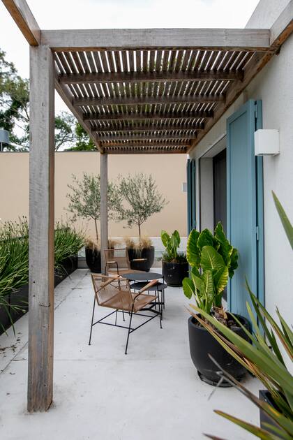 La pérgola cubre el patio, pero también funciona como parasol para el cuarto. Piso de cemento alisado.