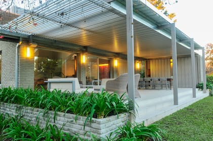 La pérgola de gran tamaño cubre la galería en su totalidad (un espacio de transición entre el afuera y el adentro) y, por el material elegido, protege del sol del mediodía sin perder luminosidad en el interior de la casa (Arq Martín Zanotti)