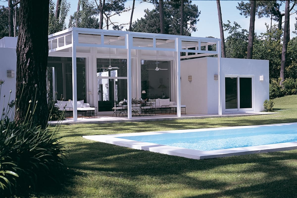 La pérgola que protege la galería con piso de cemento alisado es una estructura que resulta visualmente ligera, a pesar de su gran tamaño