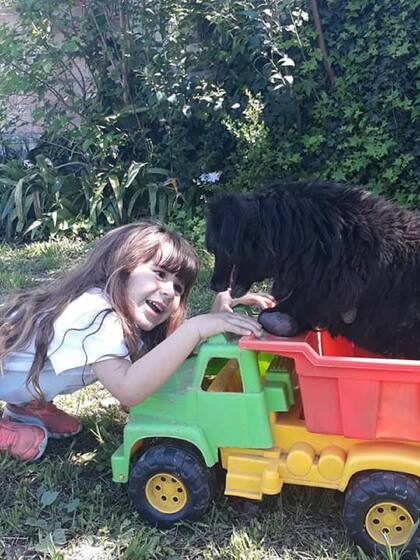 La perra Milagros en el jardín de la casa con una de sus dueñas