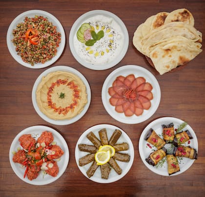 La picada armenia para compartir trae hummus, tabule, basterma, sarma frío, berenjenas yerevan, queso armenio, aceitunas negras y pan estilo árabe