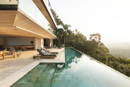 La piedra verde esmeralda se destaca en puntos estratégicos de la casa, como la piscina infinita que se funde en la selva.