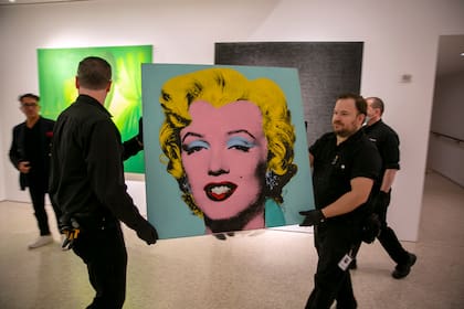 La pintura "Shot Sage Blue Marilyn" realizada por el artista Andy Warhol en 1964 es llevada a la sala de exhibiciones de Christie's, el domingo 8 de mayo de 2022, en la ciudad de Nueva York. (AP Foto/Ted Shaffrey)