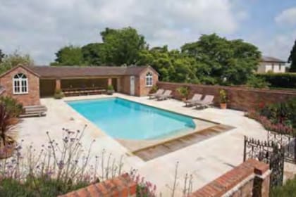 La piscina también está rodeada por los jardínes y cuenta con una cocina independiente