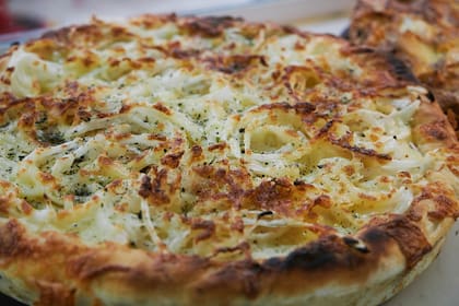 La pizza de fugazzeta rellena la prepara el maestro pizzero Gabriel Bozzuto, quien trabaja hace quince años en el local. Explota de muzzarella y tiene un toque final con aceite de oliva y provenzal.