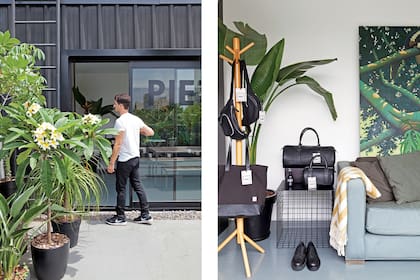 La planta en la maceta negra conversa con la pintura de detrás del sofá, un óleo que compraron juntos en Tailandia. Perchero de pie realizado en madera (Muji) y mesa de apoyo negra, hecha a medida. Mochilas, billeteras y bolso de cuero (Piet).