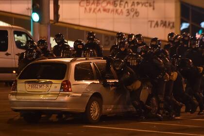 La policía antidisturbios mueve un automóvil durante un mitin de partidarios de la oposición, que acusan a Alexander Lukashenko de falsificar los resultados en las elecciones presidenciales, en Minsk el 10 de agosto de 2020