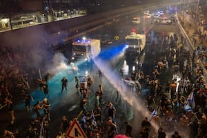La policía antimotines intenta dispersar a manifestantes con un cañón hidrante durante una protesta contra el plan del gobierno de Benjamin Netanyahu de reformar el sistema judicial, en Tel Aviv, 24 de julio de 2023. (AP Foto/Oded Balilty)