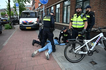 La policía de La Haya, algunos en bicicleta, deteniendo a un aficionado marroquí tras los incidentes en esa ciudad neerlandesa