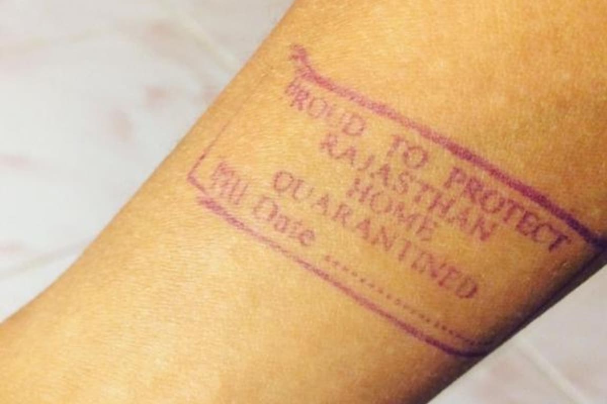 La policía de la India le pone un sello en el brazo a los extranjeros para controlar su aislamiento