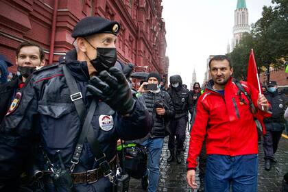 La policía escolta a un manifestante durante una protesta contra los resultados de las elecciones parlamentarias rusas cerca d ela Plaza Roja en Moscú el sábado, 25 de septiembre del 2021.  (AP Foto/Vasily Krestyaninov)