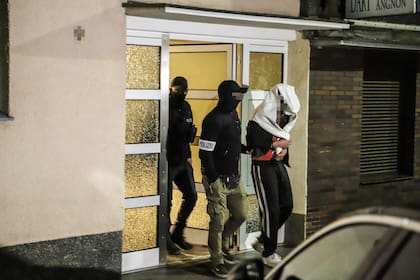 La policía guía a una persona detenida fuera de una casa residencial en Hagen, al oeste de Alemania, el 3 de mayo de 2023 como parte de una operación "a gran escala" contra la notoria mafia italiana 'Ndrangheta en toda Europa.