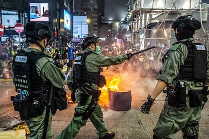 La policía hace guardia para disuadir a los manifestantes pro-democracia de bloquear las carreteras en el distrito de Mong Kok de Hong Kong el 27 de mayo de 2020