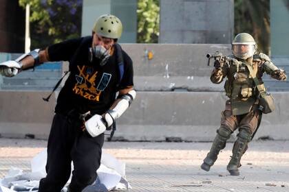 La policía lanza un proyectil a un manifestante durante las protestas en Chile