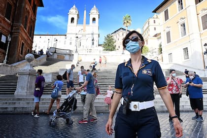 La policía local patrulla y controla que las personas utilicen tapabocas en la Plaza de España, en Roma, el 17 de agosto de 2020