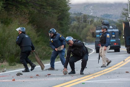 La policía retira piedras del camino colocadas por grupos mapuches que protestan por su desalojo cerca de Villa Mascardi