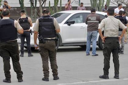 La policía rodea el auto del fiscal César Suárez, acribillado por sicarios en Guayaquil, Ecuador. (CHRISTIAN VINUEZA / AFP)