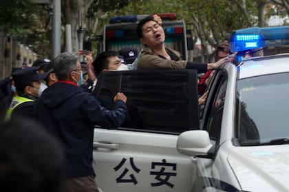 La policía se lleva a un manifestante en medio de una reciente protesta en Shanghai