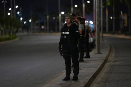 La policía vigila el inicio del toque de queda decretado por el presidente de Ecuador, Guillermo Lasso, para tratar de reducir la ola de violencia en Manta, Ecuador, el lunes 24 de julio de 2023. (Foto AP/Dolores Ochoa)