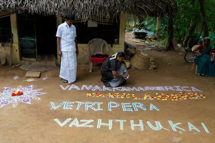 La política Arulmozhi Sudhakar prepara un kolam, una forma de arte tradicional que utiliza polvo de colores, con la frase "Saludos a America, nuestros deseos de victoria para Kamala Harris", para la candidata demócrata a la Casa Blanca, Kamala Harris, en Thulasendrapuram, el pueblo ancestral de Harris, en el estado de Tamil Nadu, India, el 5 de noviembre de 2024. (AP Foto/Aijaz Rahi)