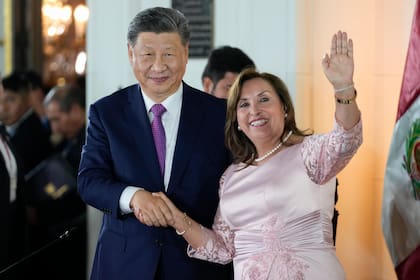 La presidenta de Perú, Dina Boluarte (derecha), y su homólogo chino, Xi Jinping, se estrechan la mano durante un acto para inaugurar virtualmente un puerto financiado por China en la ciudad de Chancay, en el palacio de gobierno en Lima, Perú, el 14 de noviembre de 2024. (AP Foto/Fernando Vergara)