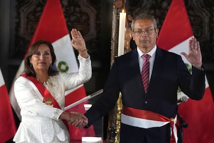 La presidenta de Perú, Dina Boluarte, y el recién nombrado jefe de gabinete, Pedro Angulo, sostienen sus manos derechas durante una ceremonia de juramentación de los miembros de su gabinete, en el palacio de gobierno en Lima, Perú, el sábado 10 de diciembre de 2022.