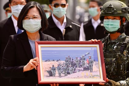 La presidenta de Taiwán, Tsai Ing-wen, recibe una fotografía enmarcada de un soldado enmascarado en medio de la pandemia de coronavirus durante su visita a una base militar en Tainan, sur de Taiwán, el 9 de abril de 2020