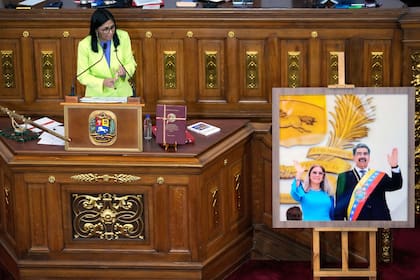 La presidenta encargada de Venezuela, Delcy Rodríguez, habla ante los legisladores junto a una foto del expresidente Nicolás Maduro y su esposa Cilia Flores, en la Asamblea Nacional, el jueves 15 de enero de 2026, en Caracas, Venezuela. (AP Foto/Ariana Cubillos)