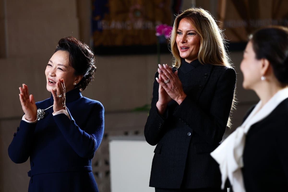 La primera dama de China, Peng Liyuan, y la primera dama Melania Trump reaccionan mientras niños de la Escuela China Hope realizan una actuación durante una visita al Museo Nacional de Arte Asiático del Smithsonian