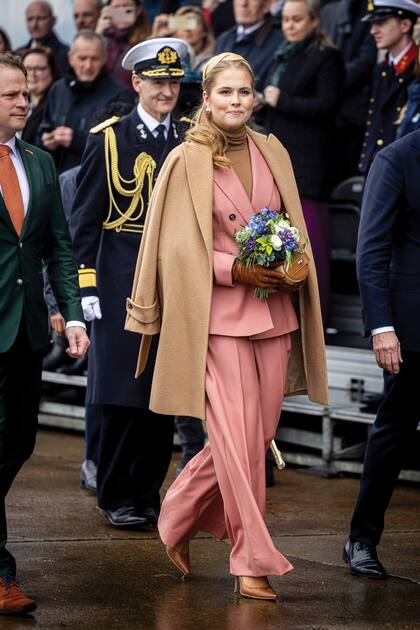 La princesa eligió un traje rosa empolvado de Max Mara, de blazer de doble botonadura y pantalón ancho pinzado, que llevó hace unos meses junto a su madre en un evento solidario en Atenas. En esta ocasión, le sumó un suéter de cuello alto y un tapado ¾ marrón de la misma firma. Sumó guantes de gamuza, cartera de mano de Marina Raphael y stilettos a tono.
