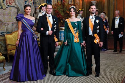 La princesa heredera Victoria –que llevó la tiara de amatistas, que originalmente era un collar– y su marido, el príncipe Daniel, posan con el príncipe Carlos Felipe y su mujer, la princesa Sofia –quien eligió una diadema de brillantes y esmeraldas, que hacía juego con su vestido–.