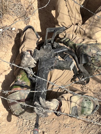 La princesa, pasando por debajo de un alambrado sin separarse de su fusil ni de sus municiones.