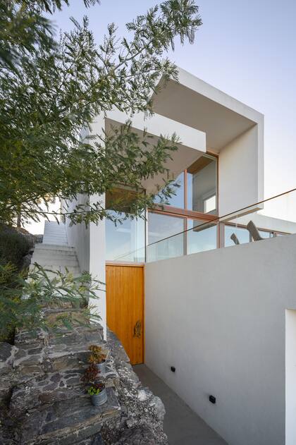 La puerta de madera conduce a la casa, mientras que la escalera que empieza con peldaños de piedra lleva directamente al estudio.