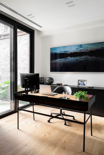 La puerta lateral del living lleva al escritorio. Aberturas de PVC (Winxs).Para el dueño de casa, contar con un escritorio fue muy bienvenido, ya que hace home office varios días por semana.