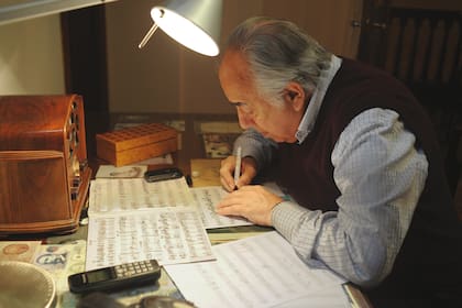 La radio antigua dominando las partituras escritas a mano en la mesa de trabajo de Manolo Juárez