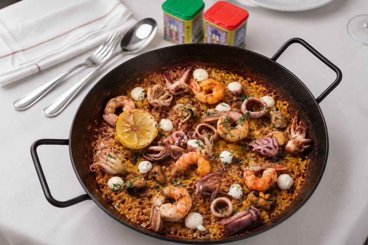 La receta de la paella Argentina de Regina suma calamares, mejillones y langostinos, junto con azafrán y pimentón español