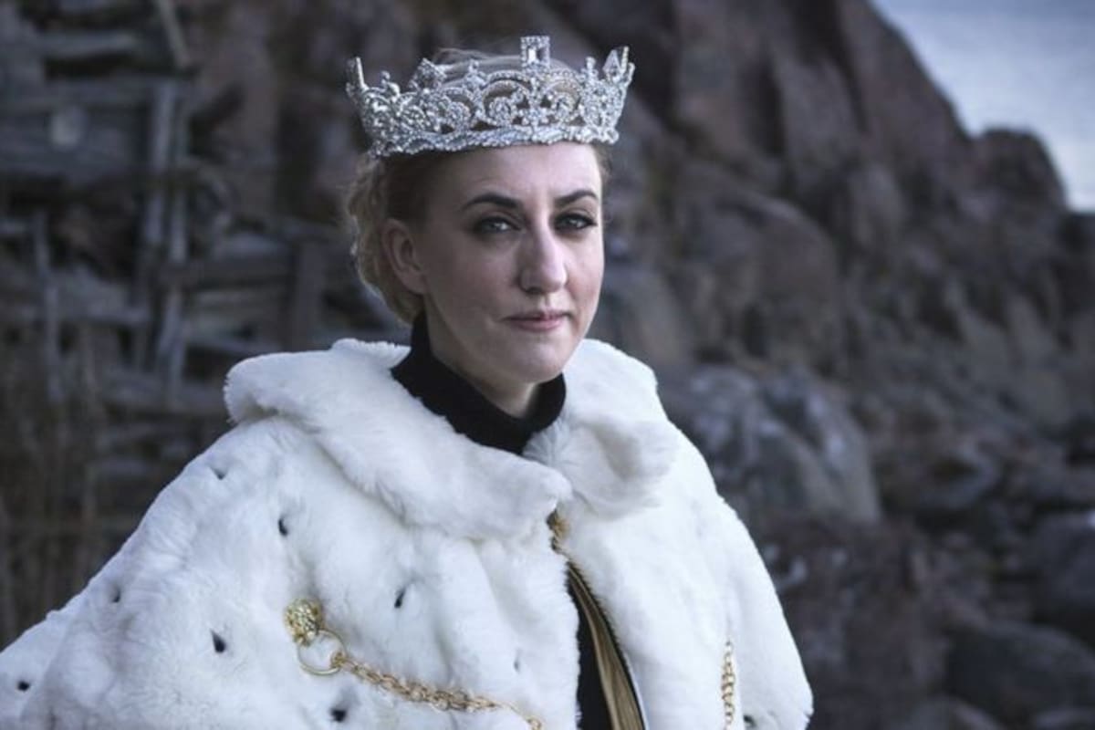 La reina Carolyn, vestida con manto y corona