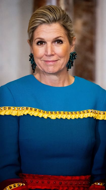 La reina combinó el colorido vestido con un par de aros colgantes de piedras azules y se recogió el cabello en un rodete (Foto: Instagram @patrickvkatwijk)