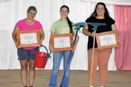 La "reina de la limpieza" y sus dos princesas en el escenario con los certificados y los distintos artículos para el hogar recibidos como premio